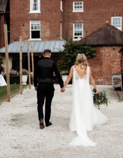 Bride and groom walking through the garden of St Johns House in Lichfield
