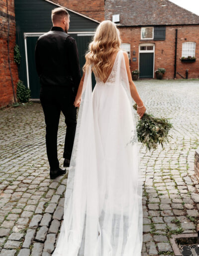 Bride and groom walking through the yard of St Johns House in Lichfield