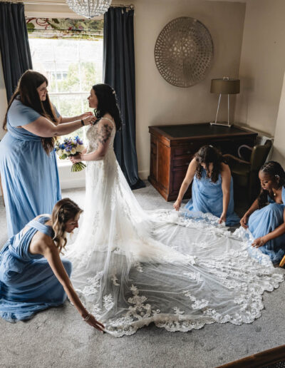 bridesmaids fixing a bride's dress