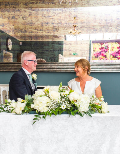 Bride and groom at the table in the ceremony room of St Johns House in Lichfield
