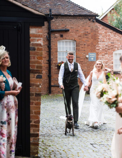 Bride and groom arriving to their reception at St Johns House in Lichfield with their dog