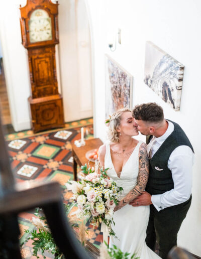 Bride and groom kissing on the stairway at St Johns House in Lichfield
