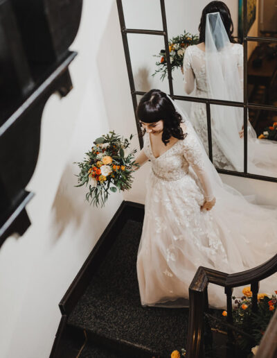 Bride walking down stairs at St Johns House in Lichfield