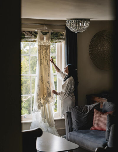 Bride getting her dress hanging in the window